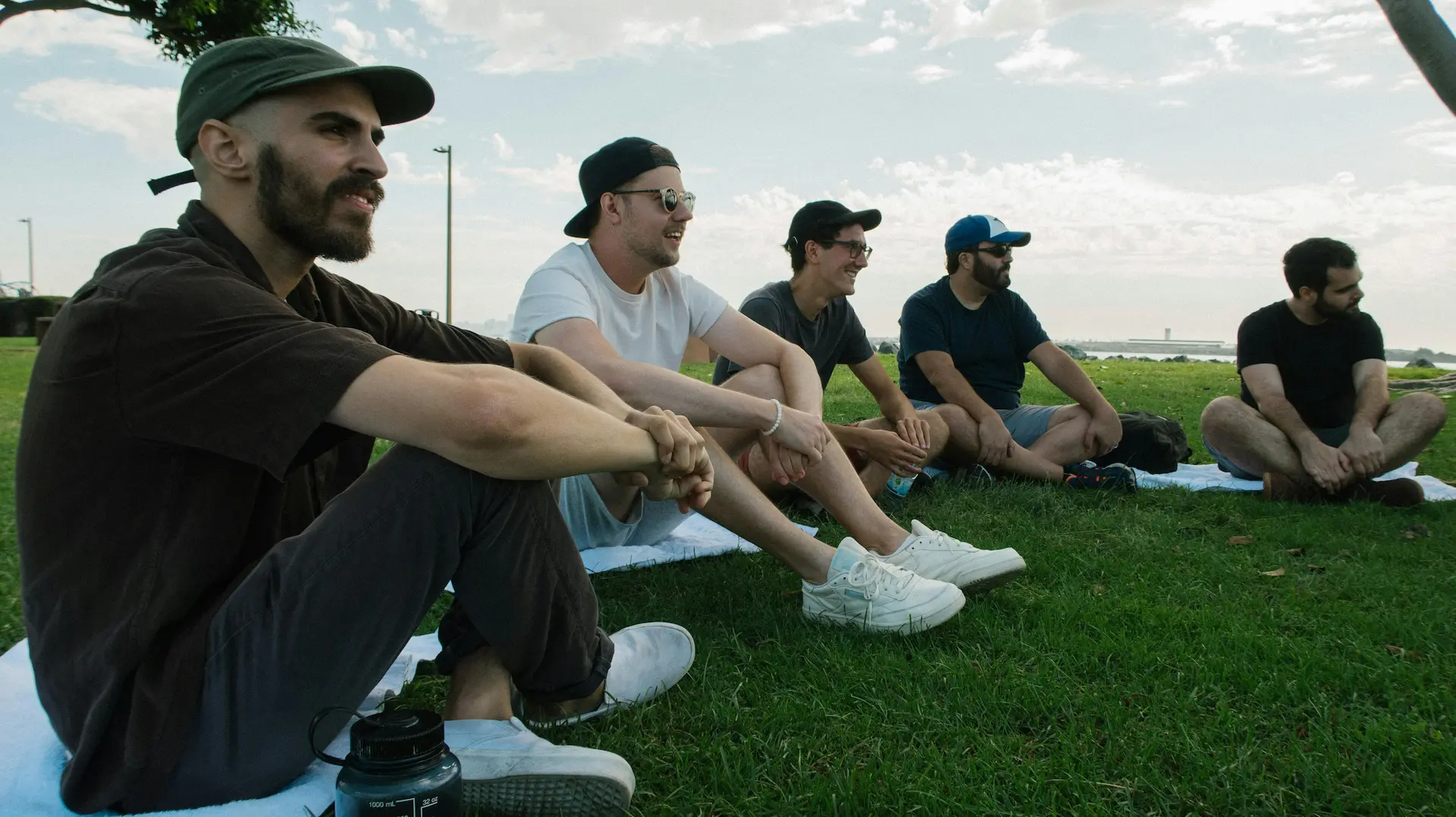 group of men sitting in a circle on green grass